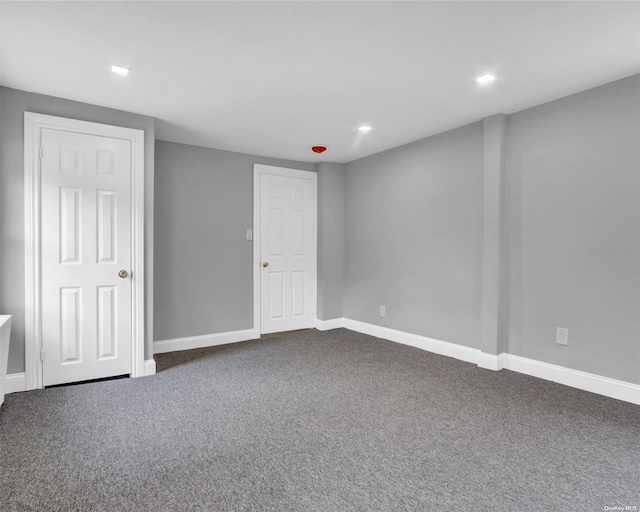 unfurnished room with dark colored carpet