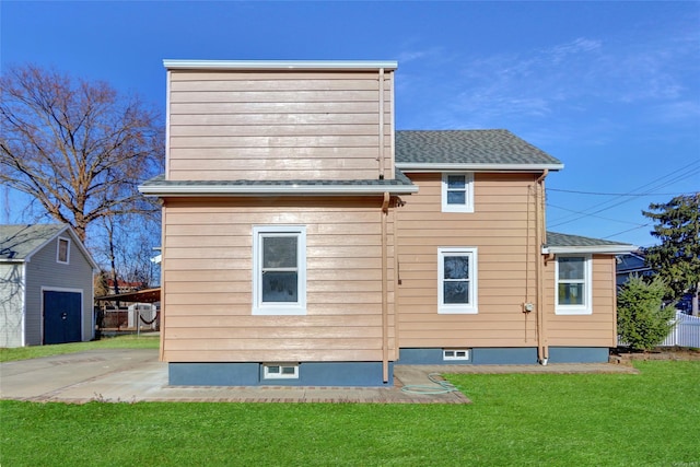 back of property featuring a yard and an outdoor structure