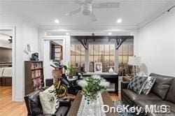 living room with hardwood / wood-style floors, ceiling fan, and crown molding