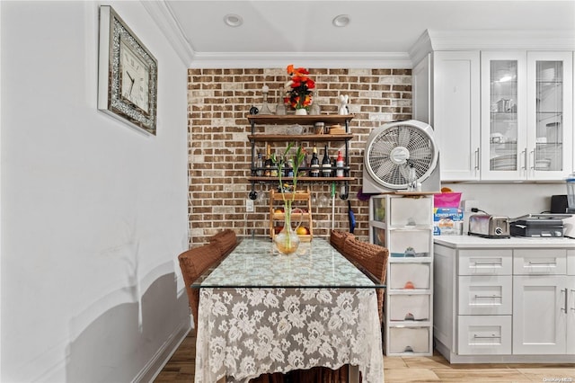 kitchen featuring white cabinets, ornamental molding, and light wood-type flooring