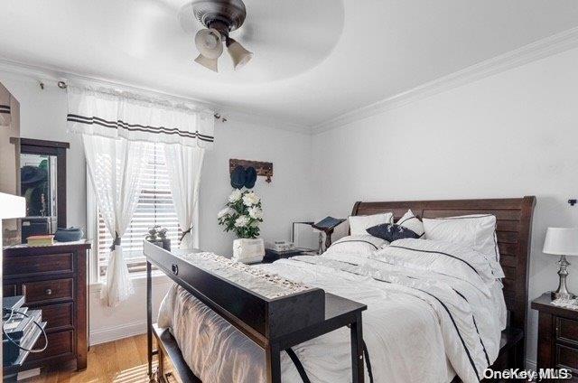 bedroom with ceiling fan, crown molding, and light hardwood / wood-style floors