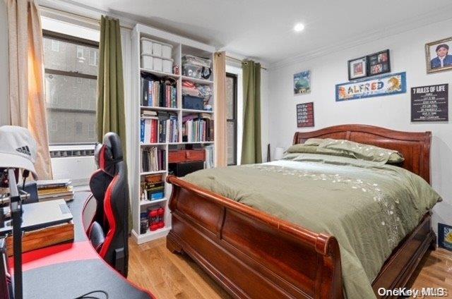 bedroom with light hardwood / wood-style flooring and ornamental molding