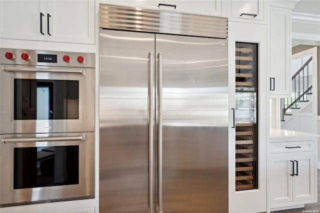 kitchen featuring white cabinetry, crown molding, and appliances with stainless steel finishes