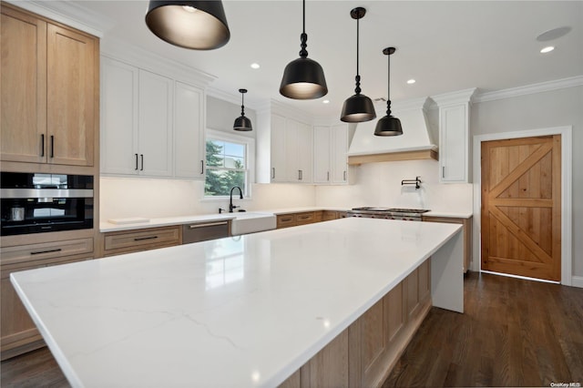 kitchen featuring a large island, white cabinetry, custom range hood, and ornamental molding