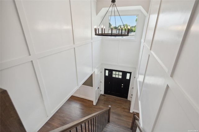 foyer entrance with dark hardwood / wood-style floors and an inviting chandelier