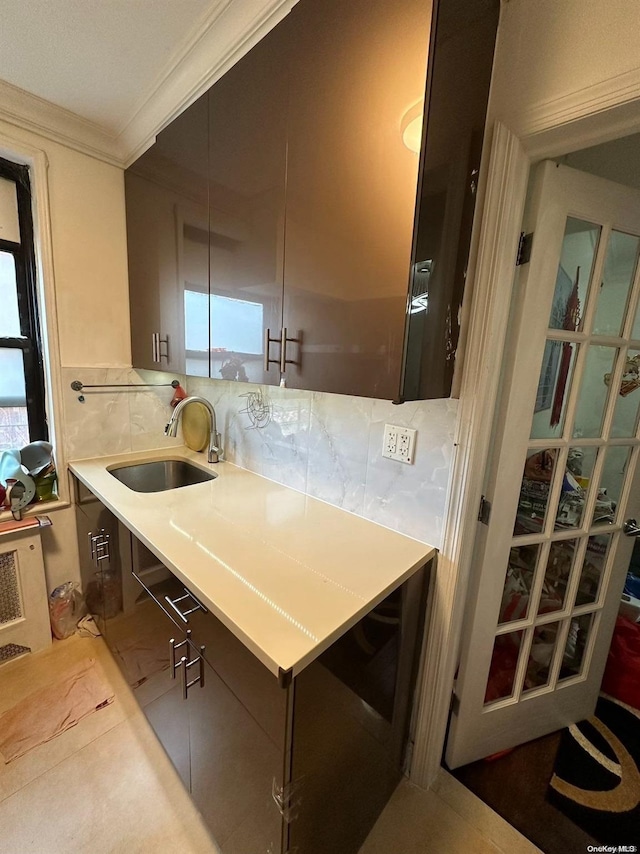 kitchen featuring tasteful backsplash, sink, and ornamental molding