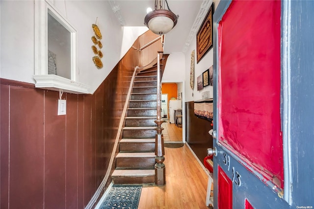 stairway with wood-type flooring and wooden walls