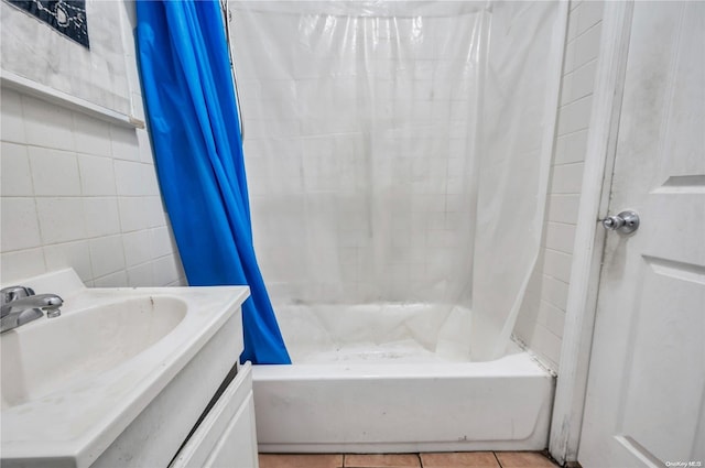 bathroom with tile patterned floors, vanity, shower / tub combo, and tile walls