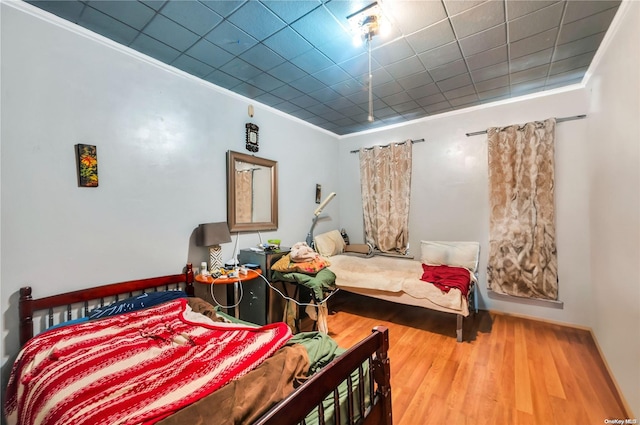 bedroom featuring crown molding and hardwood / wood-style flooring