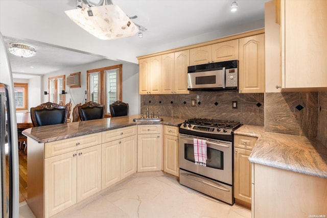 kitchen featuring kitchen peninsula, light brown cabinets, and appliances with stainless steel finishes