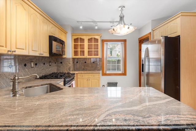 kitchen with appliances with stainless steel finishes, light brown cabinetry, and sink