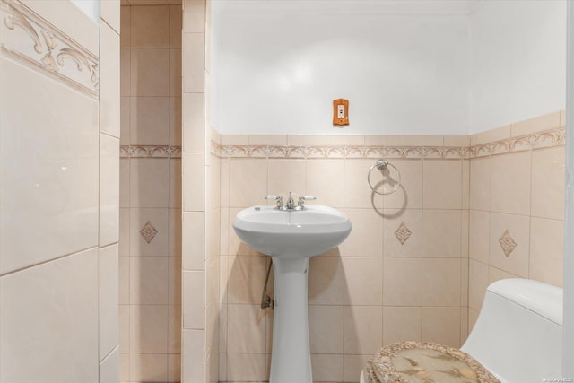 bathroom with tile walls and toilet