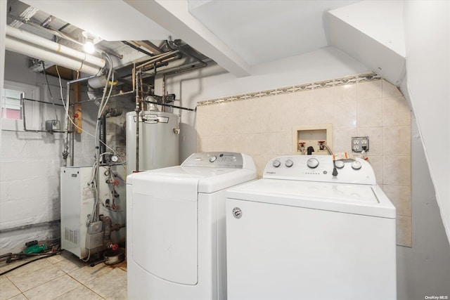 laundry area featuring light tile patterned floors, washing machine and dryer, and water heater