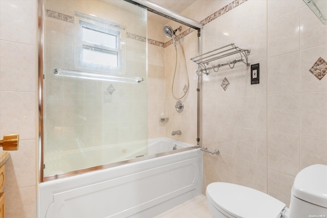 bathroom with tile patterned flooring, toilet, combined bath / shower with glass door, and tile walls