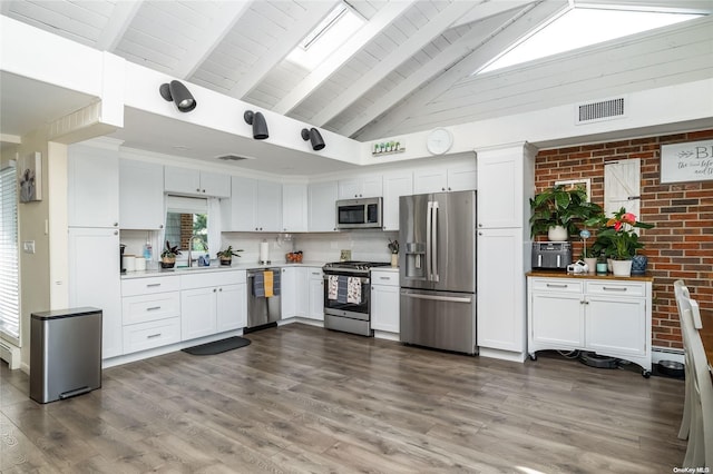 kitchen with sink, dark hardwood / wood-style flooring, white cabinetry, and stainless steel appliances