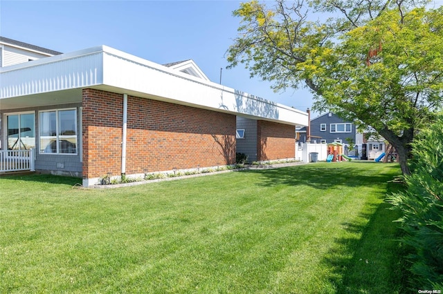 view of side of home with a playground and a yard