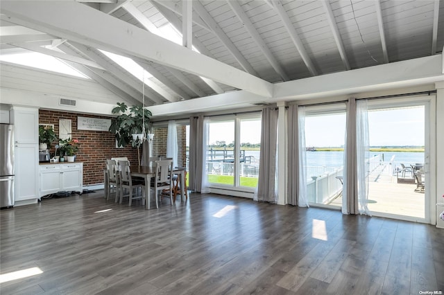 unfurnished sunroom with lofted ceiling with beams, a water view, and a healthy amount of sunlight