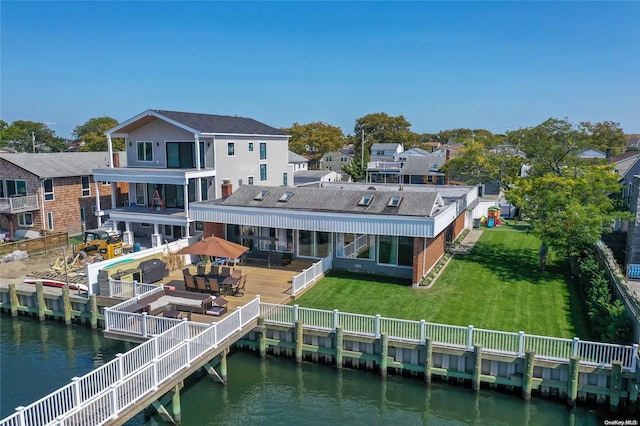 rear view of property with a lawn and a deck with water view