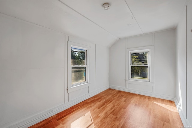 unfurnished room featuring light hardwood / wood-style flooring and lofted ceiling