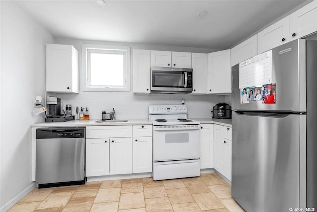 kitchen with backsplash, white cabinetry, sink, and stainless steel appliances