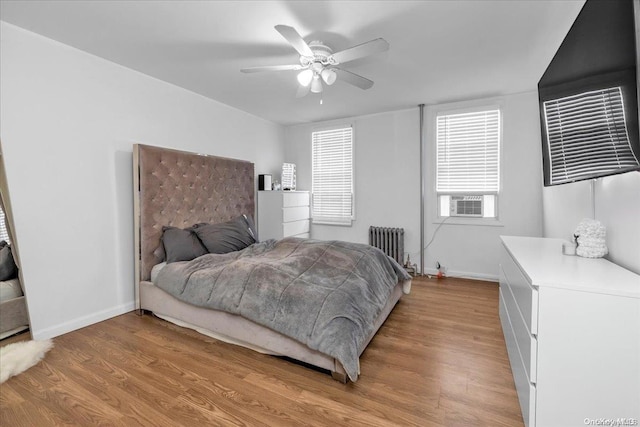 bedroom with radiator, ceiling fan, and light hardwood / wood-style flooring