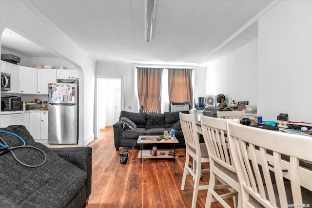 dining space with hardwood / wood-style flooring and crown molding