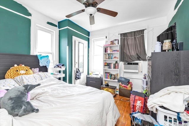 bedroom with ceiling fan, cooling unit, light wood-type flooring, and a closet