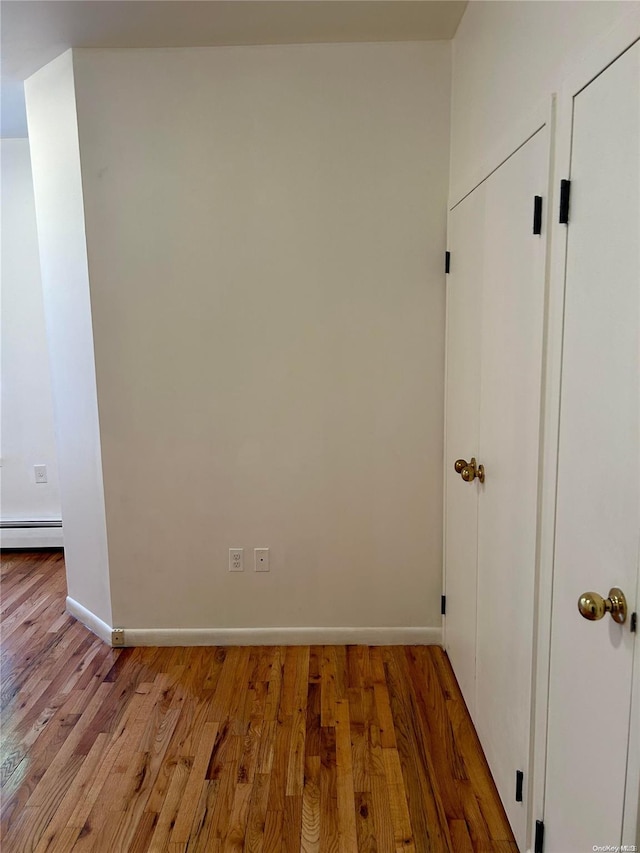 interior space with light wood-type flooring and a baseboard radiator