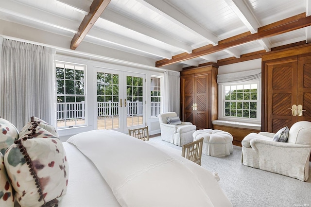 carpeted bedroom with beamed ceiling and french doors