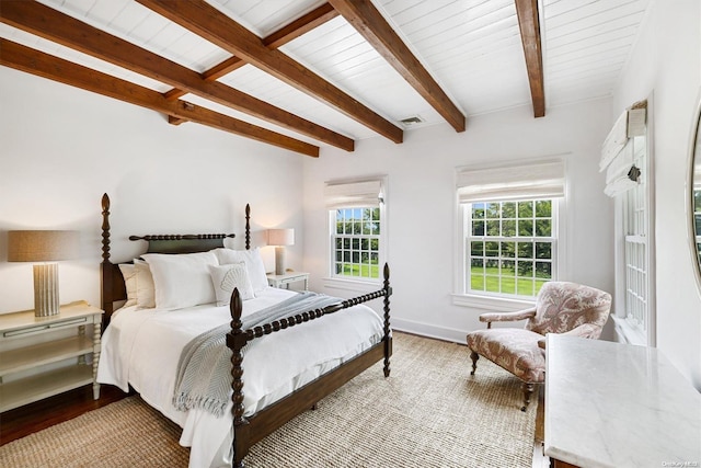 bedroom featuring beam ceiling and light hardwood / wood-style flooring