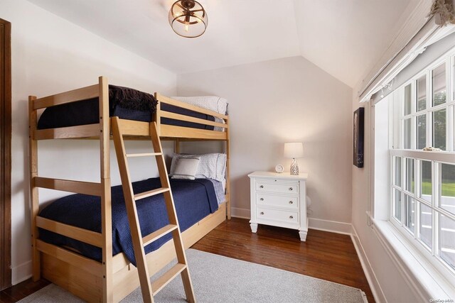 unfurnished bedroom with dark hardwood / wood-style flooring and lofted ceiling