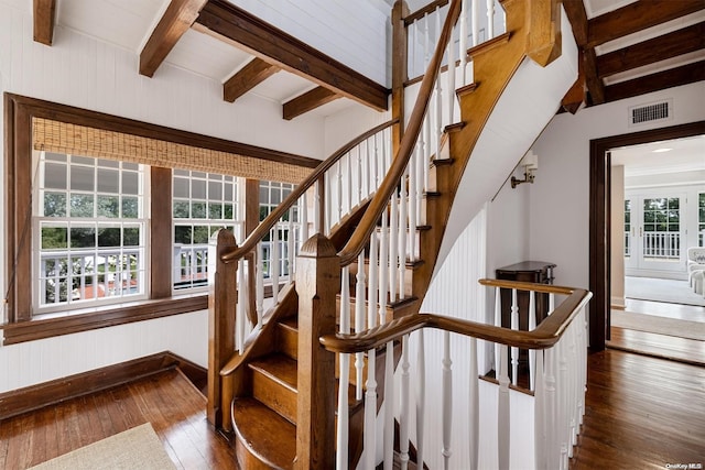 stairs with hardwood / wood-style flooring and beamed ceiling