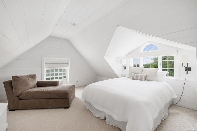 bedroom with light carpet, wood walls, and lofted ceiling