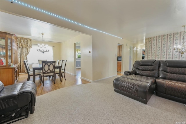 living room featuring a wealth of natural light, light hardwood / wood-style floors, and a notable chandelier