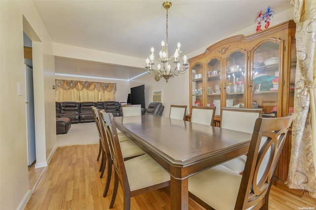 dining area with a chandelier and light hardwood / wood-style floors