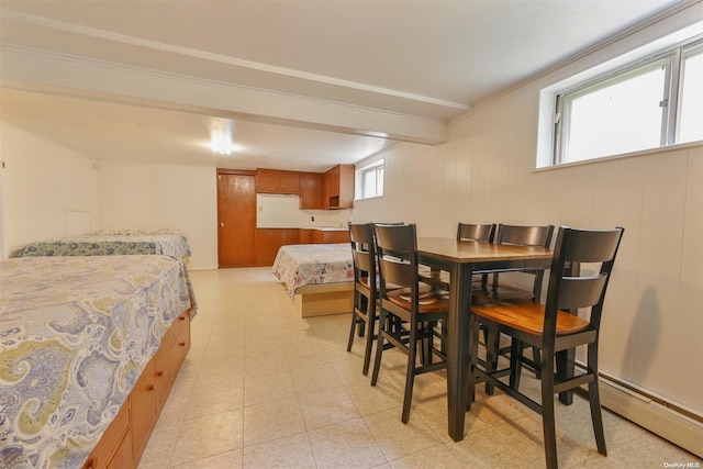 dining room with baseboard heating and wood walls