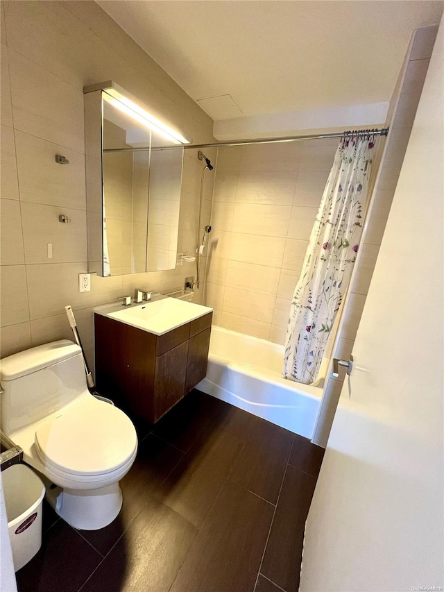 full bathroom featuring vanity, shower / bath combination with curtain, tile walls, and toilet