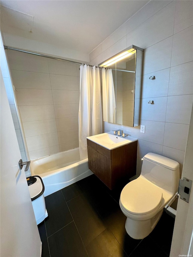 full bathroom with shower / bath combo, tile patterned flooring, toilet, vanity, and tile walls