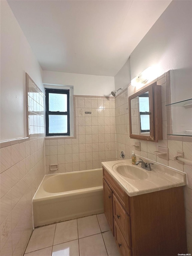 bathroom featuring tile patterned flooring, vanity, tile walls, and tiled shower / bath combo