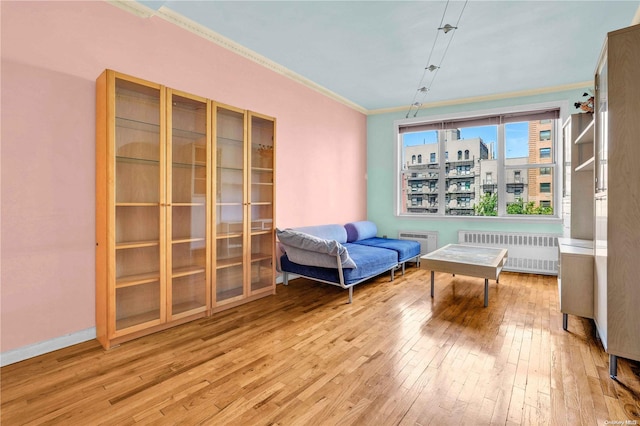 sitting room featuring light hardwood / wood-style flooring, radiator, and ornamental molding