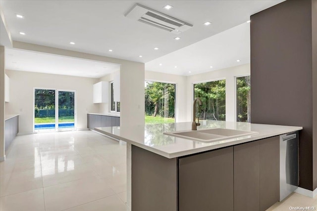 kitchen featuring dishwasher, a spacious island, sink, gray cabinets, and light tile patterned flooring