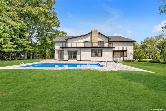 back of house with a yard, a balcony, and a patio