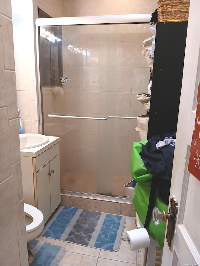 bathroom with toilet, vanity, tile patterned floors, and an enclosed shower