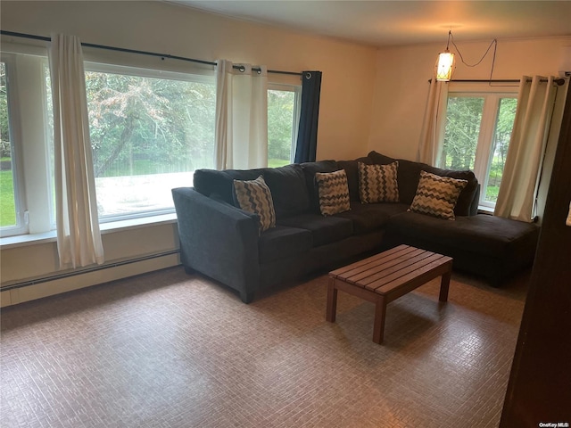 living room with a wealth of natural light, carpet floors, and a baseboard heating unit