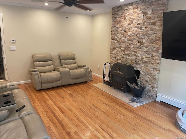 living room featuring baseboard heating, ceiling fan, light hardwood / wood-style floors, and ornamental molding