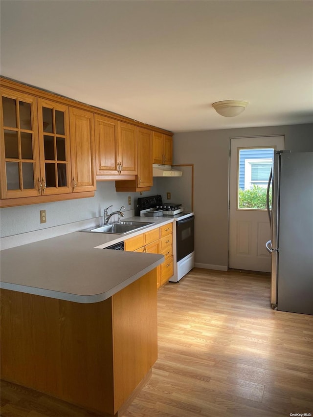 kitchen featuring sink, white electric range oven, kitchen peninsula, stainless steel fridge, and light wood-type flooring