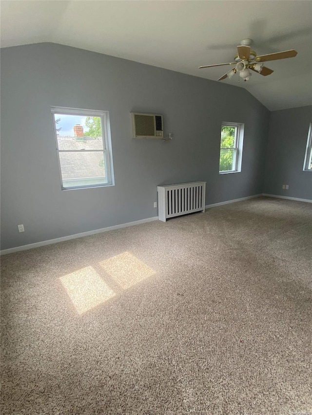 carpeted spare room with vaulted ceiling, ceiling fan, and a wall unit AC