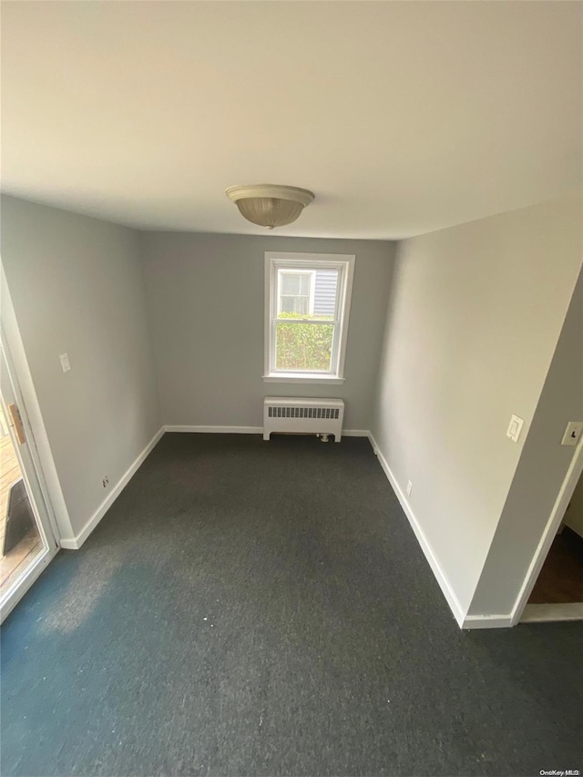 carpeted spare room featuring radiator