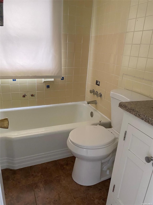 full bathroom featuring tile patterned floors, toilet, vanity, tile walls, and tiled shower / bath