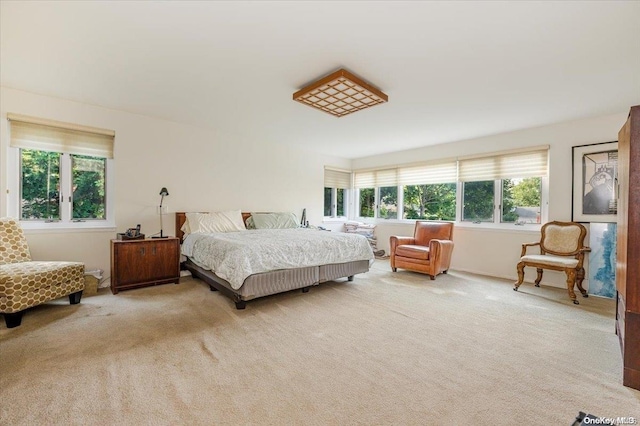 bedroom with light colored carpet and multiple windows